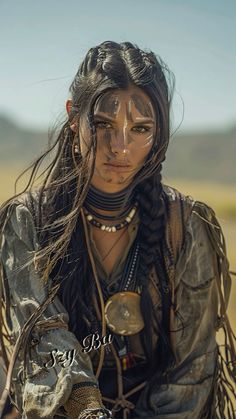 a woman with dreadlocks sitting in the desert