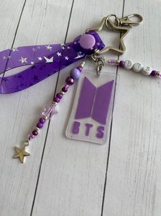 a purple lanyard keychain with the letter t on it and a star charm attached to it