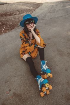 a woman sitting on the ground with her skateboard