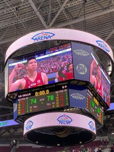 the scoreboard at a basketball game shows players on their team's big screen