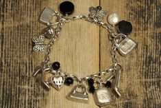 "Sterling Silver Fashion Themed Charm Bracelet. * HALLMARKS 925 and makers initials AJ * MEASUREMENTS 7 1/4\" long. Total weight is 43.8 Grams. * MATERIALS Sterling Silver, Black Onyx and Mother of Pearl. Fine sterling silver fashion themed charm bracelet featuring sterling 3d charms that include shoes, purses, compact that opens, butterflies, heart and orb. There are also a Mother of Pearl bead along with Black Onyx beads. Bracelet will arrive gift boxed. Thank you for stopping by!!" Elegant Engraved Metal Charm Bracelet, Elegant Metal Charm Bracelet With Engraving, Elegant Antique Silver Charm Jewelry, Elegant Antique Silver Jewelry With Charms, Elegant Silver Engraved Charm Bracelet, Elegant Engraved Silver Charm Bracelet, Elegant Handmade Silver Charm Bracelet, Unique Silver Bracelets With Charms, Vintage Silver Bangle Charm Bracelet