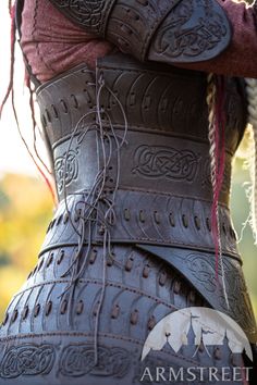 the back of a woman's leather corset with braids and buttons