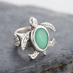 .999 Fine silver turtle ring with a green Chrysoprase gemstone. The ring band is decorated with pretty seashells and a starfish. US Ring Size 8 Turtle measures 3.1cm widest point by 3.1cm long. Chrysoprase gemstone measures 1.2cm by 1.6cm Ring band width: 1cm Handmade by Mike Summers. We are husband and wife Mike and Annie, making silver jewelry in two uniquely different styles. With a passion for rocks and gemstones, we also cut and polish our own cabochons to use in our creations. We live and work in a tiny cabin in a remote part of Talkeetna in Alaska and it's always a bit of an adventure crossing our creek in a boat to get on the roads to the post office. We have set our dispatch time to 1-2 weeks, and we usually make a visit to the post office once a week all being well. We do not wan Pretty Seashells, Unique Mini Dresses, Silver Turtle Ring, Silversmith Rings, Turtle Ring, Chrysoprase Ring, Raw Stone Jewelry, Jewelry Tattoo, Rock Jewelry