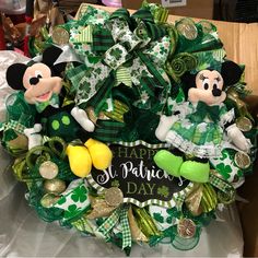 a green wreath with two mickey mouses on it