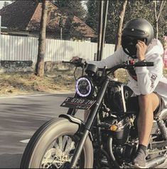 a man riding on the back of a motorcycle down a street