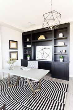 a black and white striped rug in the middle of a living room with built - in bookshelves