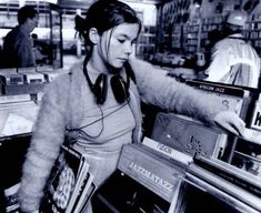 a woman in headphones is looking at records