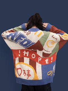 a person with their back to the camera, wearing a colorful sweater that says hope