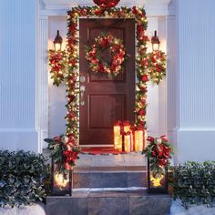 the front door is decorated for christmas with wreaths and lights