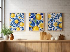 three paintings hanging on the wall above a counter