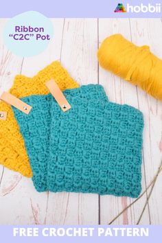 three crocheted dishcloths are sitting on a table with yarn and scissors