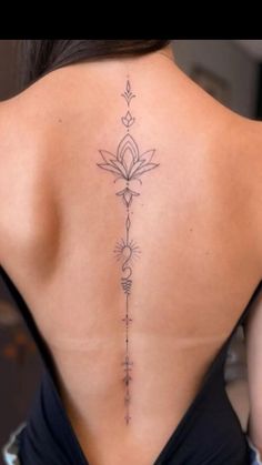 the back of a woman's body with tattoos on her upper and lower back