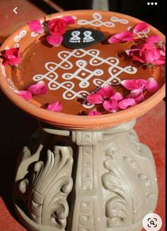 a vase with flowers in it sitting on the ground