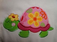 a close up of a turtle on a white shirt with flowers in it's shell