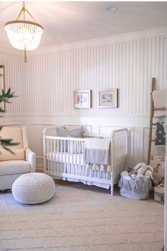 a baby's room with white furniture and striped walls