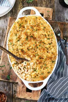 a casserole dish filled with macaroni and cheese on a wooden table