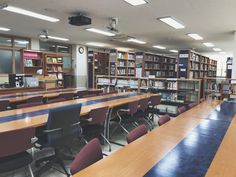 an empty library with rows of tables and chairs in front of the bookshelves