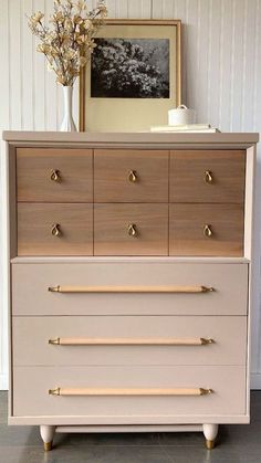 an old dresser with brass handles and knobs on the bottom, in front of a white wall