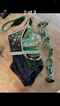 two different types of bras are shown on the floor, one has beads and is green