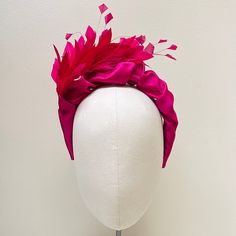 FABRIC This Women's fascinator headband has been carefully crafted and covered in magenta duchess satin and features a beautiful complementary feather corsage. The internal band is slightly padded particularly around the tips which ensures a comfortable wear at your special event. This bespoke handmade head crown is light, soft and super comfortable and boasts a quality  luxurious, sustainable finish.  FIT and SIZE A flexible base band to fit all head sizes. I do not use cheap synthetic velvetee Fitted Pink Fascinator With Feather Trim, Pink Feather Fascinator For Royal Ascot, Pink Feathered Fascinator For Races, Pink Feathered Headpiece For Races, Pink Feathered Fascinator For Evening, Pink Feather Trim Mini Hat For Evening, Pink Feather Trim Headpieces For Party, Pink Headband Fascinator For Evening, Pink Feather Trim Headpiece For Kentucky Derby