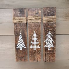 three pieces of wood with christmas trees painted on them