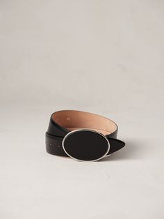 Inspired by clean and oval lines, the Flint belt emerges as a masterpiece of minimalist design, drawing inspiration from the iconic Rodeo belt. By reimagining the traditional belt buckle deeply rooted in Western lore, its curved metal detailing showcases a harmonious marriage of artistry and Americana practicality. Handcrafted in Italy of smooth, luxurious calfskin leather, our signature suede lining and a silver-tone hardware buckle. Modern Black Belt With Tang Buckle, Modern Formal Belt With Tang Buckle, Modern Formal Belts With Tang Buckle, Modern Silver Belt For Formal Occasion, Modern Business Belt Buckles With Belt Included, Elegant Tang Buckle Belt Buckles For Formal Wear, Modern Belts With Palladium Hardware For Business, Elegant Black Belt With Palladium Hardware, Modern Formal Belt Buckles With Palladium Hardware