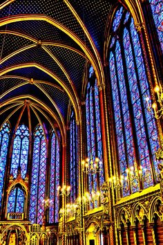 the inside of a large cathedral with stained glass windows and chandeliers hanging from the ceiling