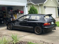 a black car parked in front of a garage