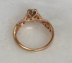 Here is a beautiful 10k rose gold ring with diamonds. The band on this ring crosses over which makes for a lovely, unique look. There is also a heart shape underneath the center stone, facing out. Just a very beautiful ring! Metal: 10k rose gold Stone: 16 dias in band, 1 center stone surrounded by 8 dia, .15cttw. Size: 6.75 Weight: 2.7 grams SKU# 10SB051418IO If you have any questions on this item, please message us! GandDJewelers.etsy.com Please note that all of our pieces have been analyzed &a Rose Gold Heart Ring With Center Stone, 14k Gold Heart Cut Rose Diamonds Jewelry, Rose Gold Heart Diamond Ring For Valentine's Day, Spiritual Heart-shaped Rose Gold Jewelry, Marquis Engagement Rings, Heart-shaped Rose Gold Diamond Ring For Valentine's Day, Metal Rings, Rose Gold Ring, Wedding Engagement