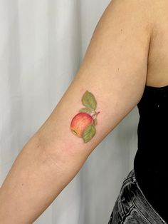 an apple tattoo on the left arm and right arm with leaves coming out of it