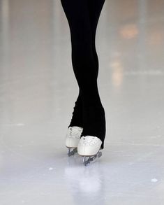 a woman in black and white skating on ice