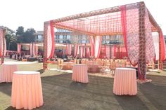 an outdoor area with tables and chairs covered in pink cloths