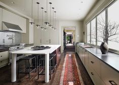 a large kitchen with lots of counter space next to a dining room table and chairs