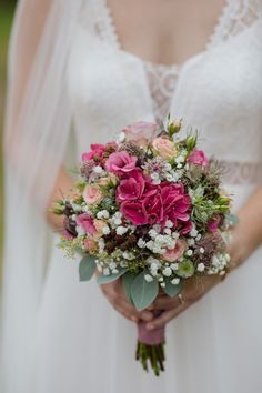 a bride holding a bouquet of flowers in her hands