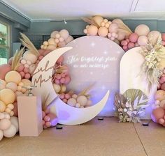 there is a large balloon arch decorated with balloons and flowers on the floor in front of it