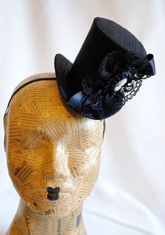 This victorian goth mini top hat is a simple yet elegant piece.It is covered with black silk shantung and adorned with black satin ribbon in a vertical half bow, vintage black cotton lace in a rosette, pleated satin ribbon, which forms an oval frame for a beautiful black and white victorian profile cameo. Choose between with or without black veil. Also available in a white and black combination: https://www.etsy.com/bizarrenoir/listing/166826619/gothic-mini-top-hat-in-purple-velvet?ref=shop_home Small Top Hat, British Hats, First Birthday Hats, Black Combination, Mad Hatter Hat, Mini Crown, White Victorian, Black Top Hat, Millinery Supplies