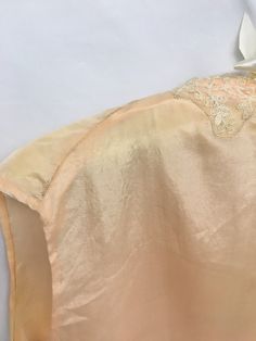 "1930s Vintage Peach sleeveless top with embroidered net lace collar and rosette. Lace is embroidered net with tropical leaves and flowers. It is set onto the neckline with zig zag around the motifs. It is not a mirror image as each side has it's own shape. The rosette is hand made of an ecru scallop trim that has been sewn into a spiral. Inside facing and front placket is hand stitched (original) Although the lace is older, it does not appear to be original to the piece. Tag/Label: N/A Material Vintage Sleeveless Wedding Tops, Vintage Sleeveless Lace Top With Lace Trim, Sleeveless Lace Work Tops For Wedding, Sleeveless Lace Top For Wedding, Vintage Sleeveless Daywear Blouse, Vintage Sleeveless Blouse For Daywear, Sleeveless Lace Top With Lace Trim For Weddings, Sleeveless Lace Trim Wedding Top, Tropical Leaves And Flowers