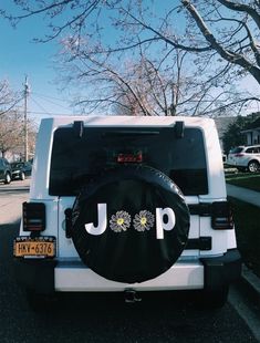 the jeep is parked on the side of the road with its spare tire cover up