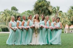 a group of women standing next to each other on top of a lush green field