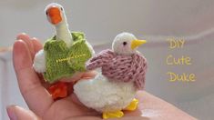 two small knitted ducks sitting on top of someone's hand with the words, diy cute duck