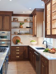 a kitchen filled with lots of wooden cabinets and white counter tops next to a stove top oven