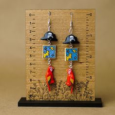 Arggg matey! A pair of earrings Captain Jack would be proud to have worn on his his ship. Handmade with 100% real Lego® parts, the dangle wire earrings have a minifigure size pirate hat, treasure map and parrot. Lightweight and funny, these statement earrings are ideal for bounding at the theme parks or on your next tropical vacation. Themed Red Earrings, Themed Pierced Earrings As A Gift, Themed Earrings For Pierced Ears As Gift, Themed Gift Earrings, Quirky Drop Earrings With Ear Wire, Themed Dangle Earrings, Themed Dangle Pierced Earrings, Quirky Red Jewelry For Gifts, Nickel-free Themed Dangle Earrings