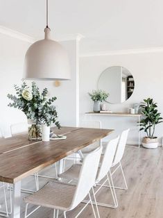 a dining room table with white chairs around it