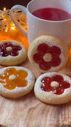 cookies with jam and jelly on them next to a cup of tea