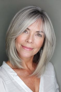 A layered bob with side-swept bangs impeccably marries texture with a contemporary edge, invigorating your chic gray hair with undeniably modern verve. Click here to check out more gray bob hairstyles that prove age is just a number when it comes to being chic. Face Framing Grey Hair, Medium Grey Hair Over 50, Grey Hair Long Bob, Cover Up Gray Hair, Gray Bob Hairstyles, Bangs For Women Over 50, Gray Hairstyles For Women, 60 And Fabulous, Gray Bob