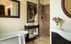 a bath room with a tub a sink and a painting on the wall next to it