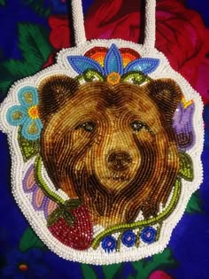 a bear with flowers and butterflies on it's head is made out of beadwork