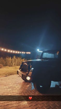 a black jeep parked on top of a brick road