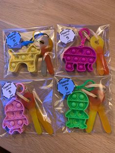 four plastic toys in the shape of giraffes with name tags on them