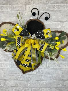 a yellow and black bow hanging on the side of a brick wall